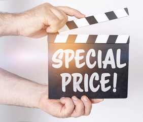 On a white background, a man holds a clapperboard in his hands on which it is written - SPECIAL...