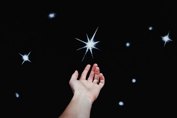 Hand reaching for a glowing star