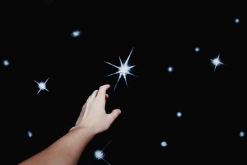 Hand reaching for a glowing star