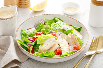 Salad with romaine lettuce, grilled chicken meat and tomatoes