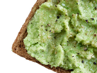 Brown cereal bread toast with salted and peppered avocado paste  isolated