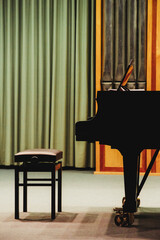 Upright image of a grand piano on an empty stage