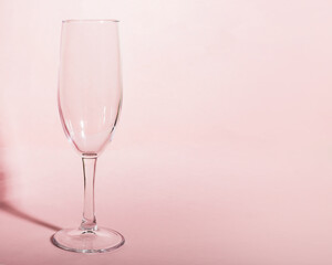 Empty tall champagne glass on pink background