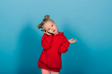Smiling little girl on the phone over blue background