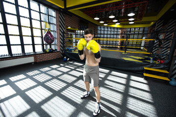 Obraz premium Collected sportsman in the boxing hall practicing boxing punches during training
