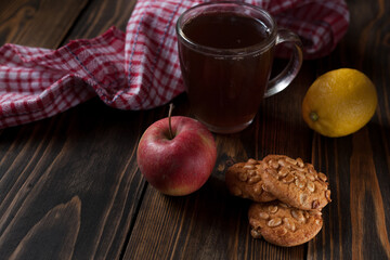 Peanut cookies, apples in the background and a mug of aromatic tea. On a wooden background. With space for your text. 