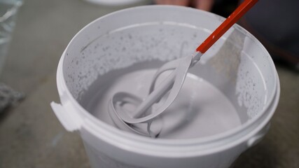 White paint in a bucket. White paint screwdriver.