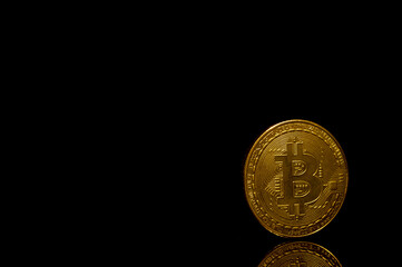 Golden bitcoin over black background.