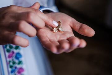 Earrings in the hands of the bride. Bridal wedding accessories