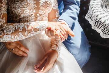 the bride sits on the groom's lap, holding hands