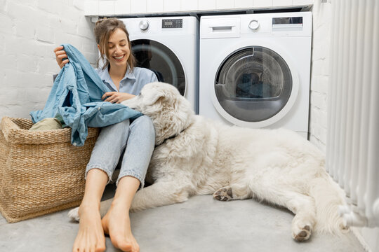 Woman with a dog doing housework in the laundry