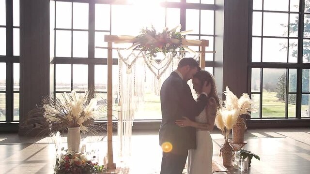 Newlywed couple touching foreheads at wedding alter, beautiful venue bright sunshine. HD 24FPS.