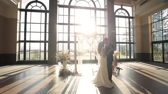 Newlywed couple touching foreheads at wedding alter, beautiful venue bright sunshine. HD 24FPS.