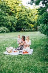 Young family with children having fun in nature. Two young mothers friends with kids toddlers are...