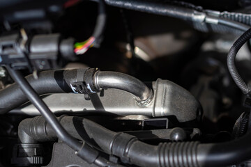 soft depth of field. Natural light. the car. Engine compartment. Metal tube for supplying liquid to...