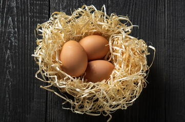 Brown eggs in the nest on the farm. Decorating a nest made of wood sawdust.