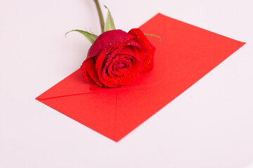 Red rose and envelope with copy space, laying on white table. Valentine's day background, love and romance.