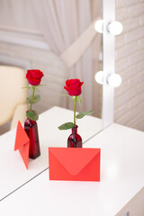 Red rose and envelope with copy space, on table in beauty salon. Valentine's day background, love and romance.