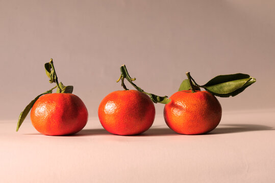 Three tangerines in a row on a table