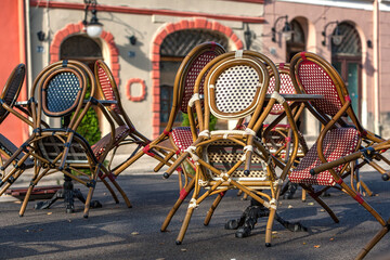An empty summer outdoor area of a restaurant or cafe in a historic downtown is closed during lockdown. Tables and chairs without visitors. Challenging times business in HoReCa during a pandemic.