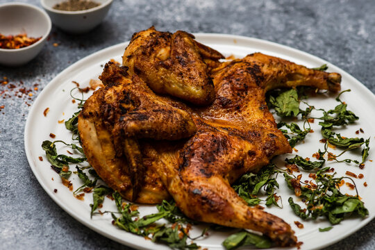 Georgian pan fried chicken tabaka with fried coriander leaves and chilli flakes