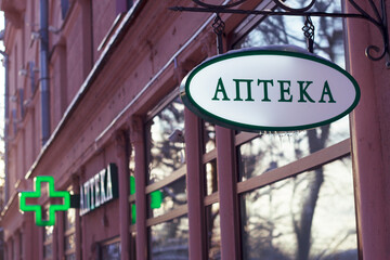 Obraz premium Winter city street with pharmacy and signboard with text in russian 