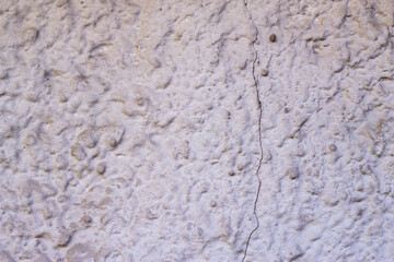 Plastered rough wall with long crack. Textured city surface background. Grey decorative backdrop. Copy space for text.