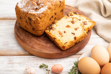 Homemade easter pie with raisins and eggs on plate on a white wooden background. side view, close up.