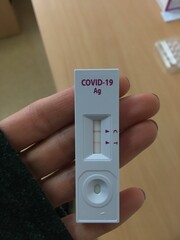 Close up of a hand holding positive test:
Jco Covid-19 virus.
