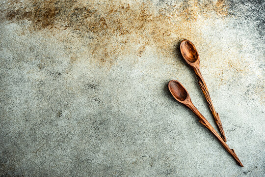Two wooden spoons on a rustic table