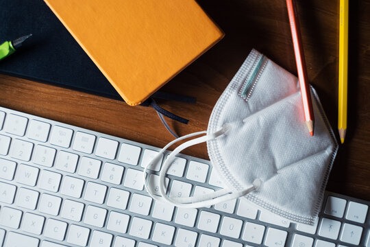 Close Up Protective Mask N95 Respirator Hanging On Computer Screen On Wooden Table