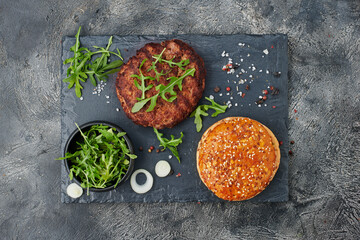 Top view and flat lay of burger ingredients on dark table