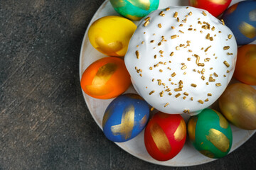 Easter cake and Easter eggs on a dark background top view with copy space.