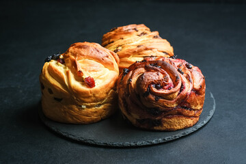 Cruffin with dried fruits on a dark background.