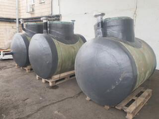 Fototapeta na wymiar Green horizontal fiberglass container tanks of high strength and a wide range of uses: for sewerage, storage of drinking water and food supplies. ?hemical resistant tanks.