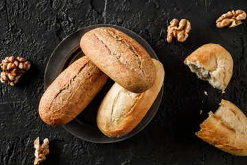 Fresh bread on black stone background. Whole wheat bread, healthy concept, bakery products