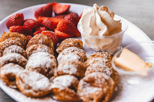 Tasty Dutch Poffertjes with Strawberries, Cream and Toppings
