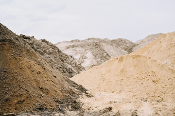 Heaps of sand at a construction site on an overcast day