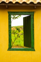 old green farm window with yellow wall