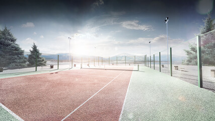 Tennis court on the river bank. Sunshine. View from above. Mountains in the background. Tennis background