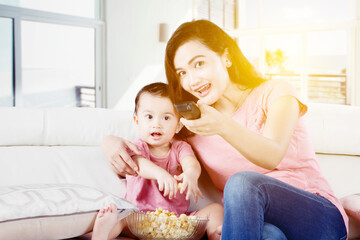 Mother enjoying watches television with daughter