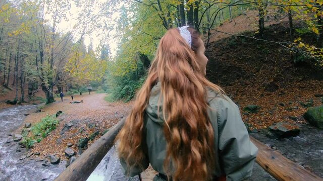 Hiking. The girl is walking on a wooden bridge.
