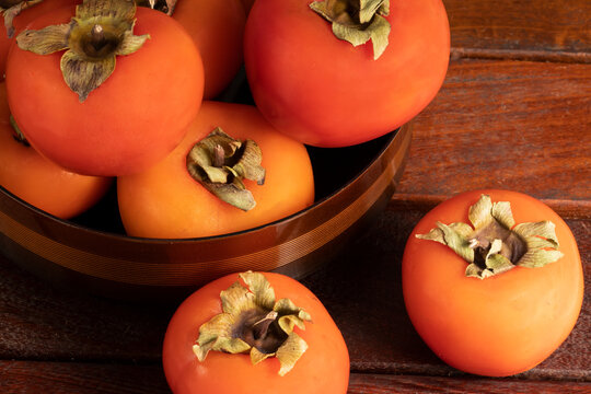Some delicious persimmons on the wooden table.