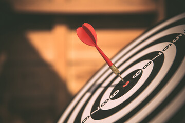 Fototapeta premium Close-up the bullseye or bulls eye target or dart board has dart arrow throw hitting the center of a shooting for business targeting and aim to winning goals concepts