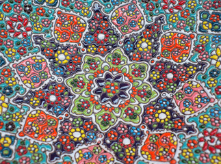 Pattern of an Iranian clay plate decorated with small pieces of colorful ceramics