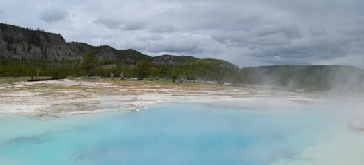 Late Spring in Yellowstone National Park: Sapphire Pool of the Sapphire Group in the Biscuit Basin Area of Upper Geyser Basin with the Madison Plateau in the Background