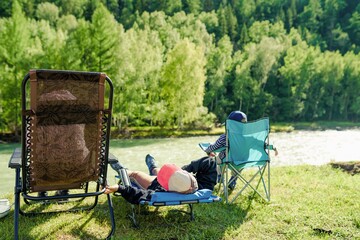 Family resting on the beach of mountain river