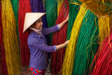 Vietnamese female craftsman drying traditional vietnam mats in the old traditional village at dinh...