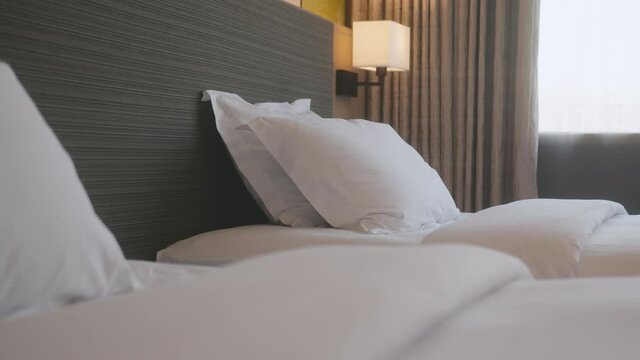 dolly shot 4k footage of beautiful casual white soft pillow and bed sheet bedroom confortable relax interior design home interior detail concept