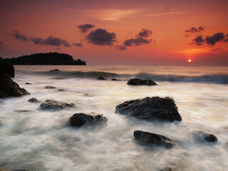 Beautiful natural seascape wave moving on the rock during sunrise